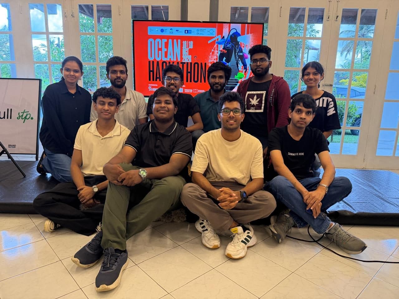 Ocean Hackathon participants posing in front of the event screen
